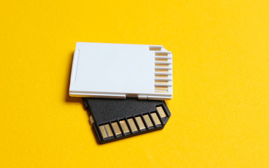 Two Mini SD memory cards on yellow background close up
