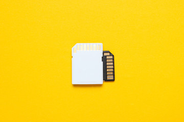 Two Mini SD memory cards on yellow background. Top view