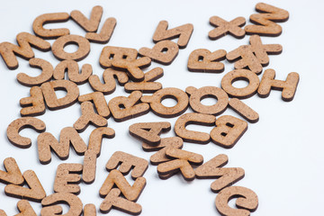 Many wooden letters on white background close up