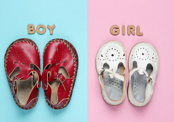 Children's sandals for boy and girl on pastel blue-pink background. Top view