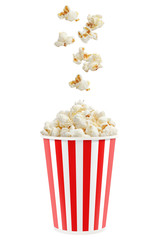 Popcorn falling into a red striped paper cup, isolated on white background