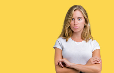 Beautiful young woman wearing casual white t-shirt over isolated background skeptic and nervous,...