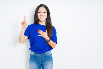 Beautiful brunette woman over isolated background Swearing with hand on chest and fingers, making a...