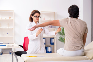 Obraz premium Female doctor checking patient's joint flexibility with goniometer