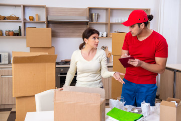 Young male contractor and female customer in moving concept  