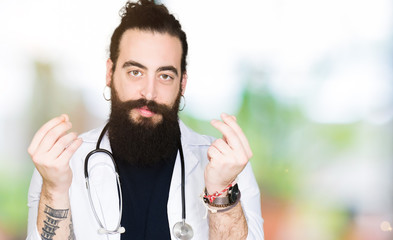 Doctor with long hair wearing medical coat and stethoscope Doing money gesture with hand, asking for salary payment, millionaire business