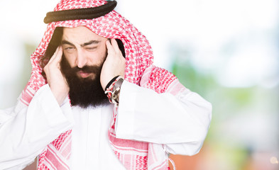 Arabian business man with long hair wearing traditional keffiyeh scarf covering ears with fingers with annoyed expression for the noise of loud music. Deaf concept.
