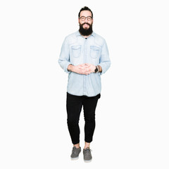 Young hipster man with long hair and beard wearing glasses Hands together and fingers crossed smiling relaxed and cheerful. Success and optimistic