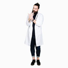 Doctor with long hair wearing medical coat and stethoscope Suffering pain on hands and fingers,...
