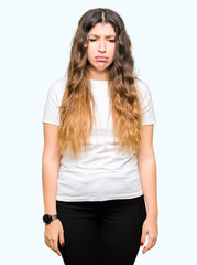 Young beautiful woman wearing casual white t-shirt depressed and worry for distress, crying angry and afraid. Sad expression.