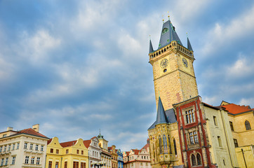 Amazing view of the Old Town Hall in Prague, Czech Republic photographed during sunrise golden hour with dark clouds above. Famous tourist place in Czechia. Horologe tower. Amazing landmarks