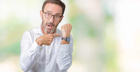Handsome middle age elegant senior business man wearing glasses over isolated background In hurry pointing to watch time, impatience, upset and angry for deadline delay