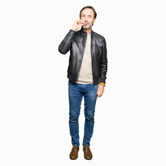 Middle age handsome man wearing black leather jacket mouth and lips shut as zip with fingers....