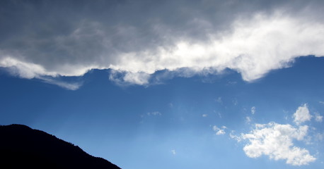 Dunkle Wolkendecke &uuml;ber blauen Himmel