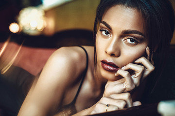 Beautiful dark-skinned young woman sensualy posing in black lingerie. Fashion Photoshoot.
