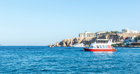 Beautiful seascape with ship which floating near rock.