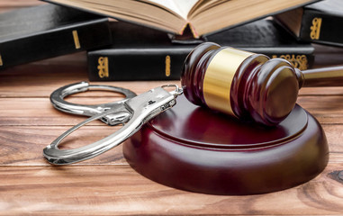Gavel, handcuffs and books on the table. Law and justice concept.