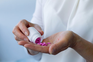 woman puts pills on her hand