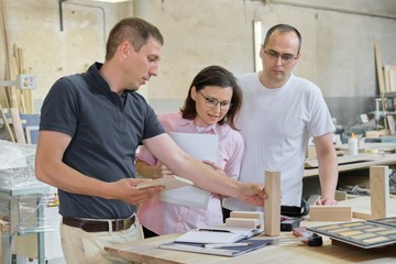 Group of people designer, client, carpenter, engineer choosing wooden products
