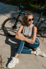 Pretty woman with Bicycle on a background of palm trees forest. Young girl riding bike in Vietnam or Thailand tropical jungle with coconut palms. Summer holiday tourist activity. Active sports tourism