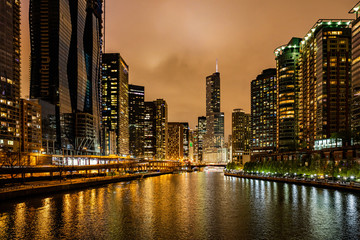 Chicago city illuminated buildings in the evening. Reflections on the river canal