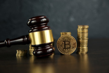 Auction gavel and bitcoin cryptocurrency money on a wooden desk, close-up. Law Gavel and golden bitcoin symbol on white background with copyspace
