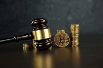 Auction gavel and bitcoin cryptocurrency money on a wooden desk, close-up. Law Gavel and golden...