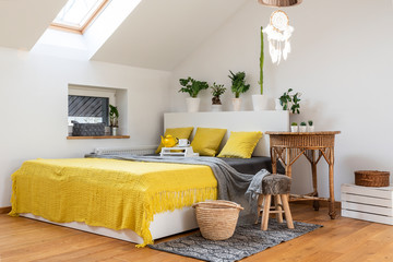 Interior of bedroom  in white and yellow colours in scandinavian style  with plants
