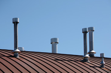 Array of ventilation pipes and air ducts on the roof of a modern industrial building