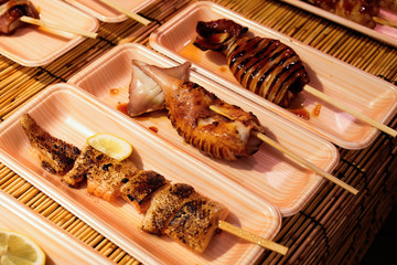 Large barbecued squid sold in Japanese street food market in Osaka.