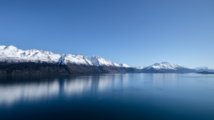 New Zealand travel image of Lake Wakatipu with snow mountain and blue mirror lake. Peaceful image...