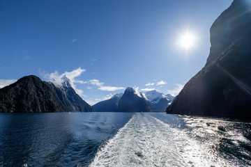 In Milford Sound cruise, one experience the spray of a waterfall close to sheer rock faces. A popular tourist destination and natural landscape in New Zealand. This view is breathtaking and iconic.