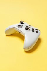 White joystick gamepad, game console on yellow colourful trendy modern fashion pin-up background. Computer gaming competition videogame control confrontation concept. Cyberspace symbol