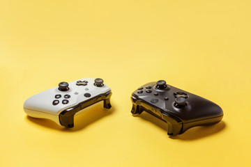 White and black two joystick gamepad, game console on yellow colourful trendy modern fashion pin-up...