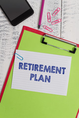 Writing note showing Retirement Plan. Business concept for saving money in order to use it when you quit working Clipboard sheet pencil smartphone squared note clips wooden background