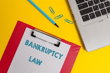 Word writing text Bankruptcy Law. Business photo showcasing Designed to help creditor in getting the asset of the debtor Open laptop clipboard blank paper sheet marker clips colored background