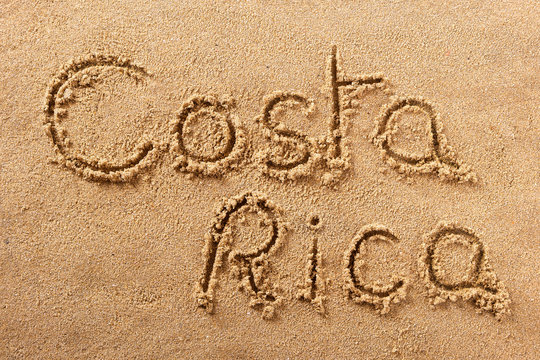 Costa Rica word written in sand sign writing drawing drawn on a sunny summer beach holiday vacation travel destination message photo