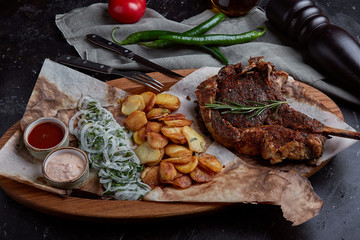 Tomahawk steak with vegetables and a knife on the table. Grilled meat with grilled vegetables and...