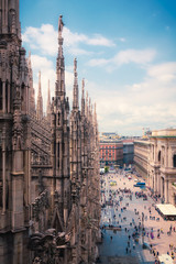 Fototapeta premium Widok osób korzystających z Piazza del Duomo z ozdobną architekturą katedry w Mediolanie, Lombardia, Włochy