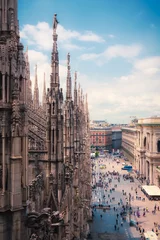  View of people enjoying Piazza del Duomo with the ornate architecture of the  Milan Cathedral Lombardy, Italy © heyengel