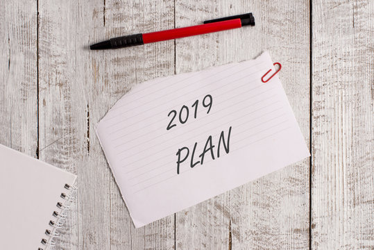 Word writing text 2019 Plan. Business photo showcasing setting up your goals and plans for the current year or in 2019 Torn paper and notebook sheet with a pen placed on top of wooden table
