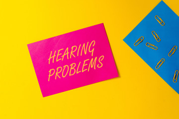 Conceptual hand writing showing Hearing Problems. Concept meaning is partial or total inability tolisten to sounds normally Blank paper sheets message reminder clips binders color background