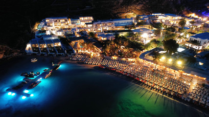 Aerial drone night shot of famous Psarou beach with luxury resorts and yachts docked, Mykonos island, Cyclades, Greece - obrazy, fototapety, plakaty