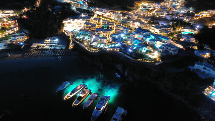 Aerial drone night shot of famous Psarou beach with luxury resorts and yachts docked, Mykonos island, Cyclades, Greece