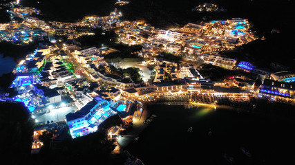 Aerial drone night shot of famous Psarou beach with luxury resorts and yachts docked, Mykonos island, Cyclades, Greece