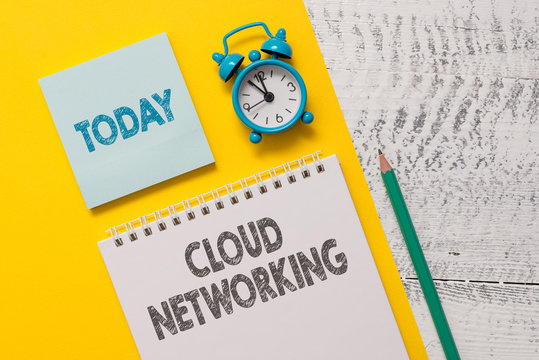 Text sign showing Cloud Networking. Business photo showcasing is term describing access of networking resources Spiral notepad paper sheet marker alarm clock retro wooden background