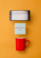 Word writing text Immigration Law. Business photo showcasing Emigration of a citizen shall be lawful in making of travel Coffee cup colored sticky note electronic device yolk color background