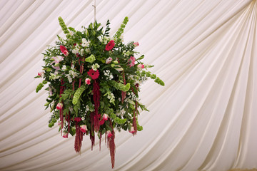 bouquet of flowers hanging against a white silk curtain