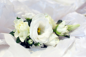 white wedding flowers against a white silk background