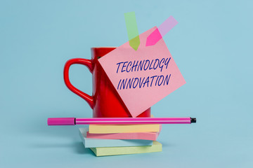 Word writing text Technology Innovation. Business photo showcasing significant technological changes of products Cup sticky note arrow banners stacked pads pen lying pastel background